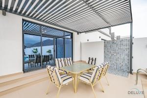 a dining room with a table and chairs at Deal of the Week 4BR with Pool, Sea & Mountain Views by Deluxe Holiday Homes in Sharm