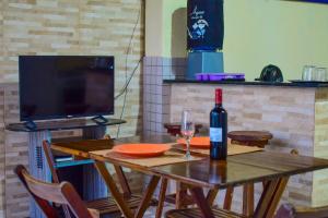 a table with a bottle of wine and a glass at CASA DE TEMPORADA RECANTO FELIz 2 in Aracaju