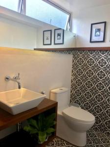 a bathroom with a white sink and a toilet at Casa Bianca Dumaguete in Bolocboloc