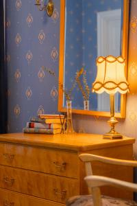 a desk with a lamp and a dresser with a mirror at Orkla Gjestebolig in Løkken