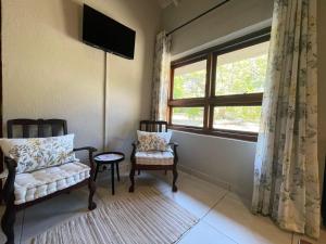 a living room with two chairs and a window at Betel in White River