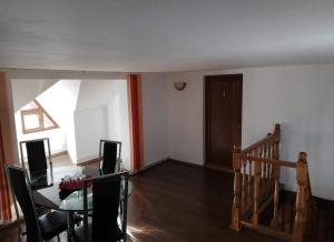 a living room with a dining room table and a staircase at VILA Jo in Brebu