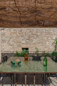 einen Tisch mit einer Flasche Wein an einer Steinmauer in der Unterkunft Luxury house with pool - Lumio in Lumio