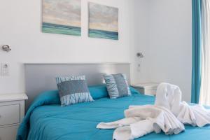 Una cama azul con una toalla encima. en Home2Book Green Oasis Charming Duplex Maspalomas, en Maspalomas 26 fotos más