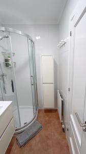 a white bathroom with a shower and a sink at Comillas - Urbanización Lagos Azules - Netflix, Prime, Wifi & Free Indoor Parking in Casasola +18 photos