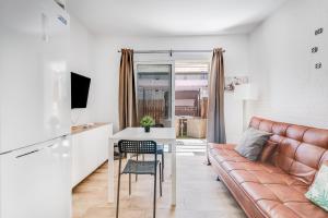 una sala de estar con un sofá y una mesa en Home2Book Green Oasis Charming Duplex Maspalomas, en Maspalomas