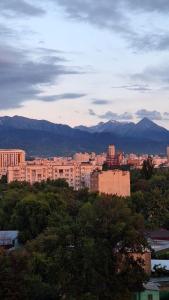 una ciudad con edificios y montañas en el fondo en Оскар, en Almaty