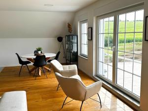 a living room with chairs and a table and windows at Luxeriöse Auszeit im Dreiländereck in Château-Rouge
