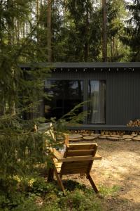 eine Hütte im Wald mit einem Picknicktisch und einer Bank in der Unterkunft Miško terapija po egle in Kriviliai