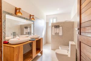 a bathroom with two sinks and a mirror at Maharaja Boutique Hotel Zanzibar in Uroa +36 photos