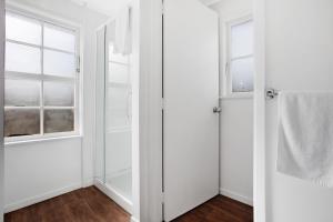 オークランドにあるSunny Beam Guest Suite with Parking and Kitchenetteの2つのドアと窓がある白いバスルーム +14枚の写真