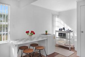 オークランドにあるSunny Beam Guest Suite with Parking and Kitchenetteのカウンターとスツール、電子レンジ付きのテーブルを備えたキッチン