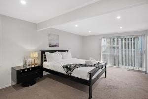 オークランドにあるSunny Beam Guest Suite with Parking and Kitchenetteのベッドと窓のある白い寝室