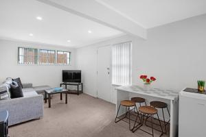 オークランドにあるSunny Beam Guest Suite with Parking and Kitchenetteのソファとテーブルのあるリビングルーム