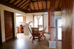 a kitchen and dining room with a table and chairs at Casa Buyan in Singaraja