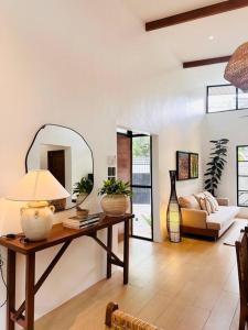 a living room with a table and a mirror at Yucca Villa - Stylish City Retreat in Bolocboloc