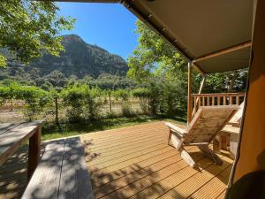 a deck with a bench and a view of a mountain at Tiendas safari Chill-Outdoor in Perarrua +7 photos