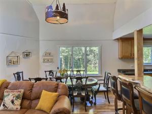 a living room with a couch and a table at DancingBears- 8BR, 2 Hot Tubs, 2 Homes, Game Room, AC! in Killington