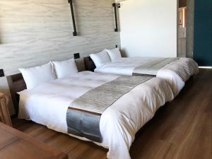 two beds in a hotel room with white sheets at Free Parking and Sauna INDIGO GEO HOUSE DS2DS3 in Tajiri +63 photos
