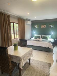 a bedroom with a large bed and a table in it at Betel in White River +58 photos