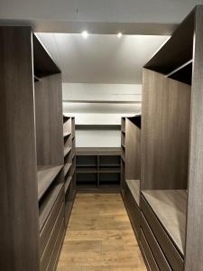 a walk in closet with dark wood cabinets and wood floors at FREJUS - Appartement 4 personnes - Piscine in Fréjus +6 photos