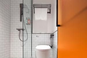 une salle de bain avec douche et toilettes dans l'établissement Merica Hotel-Chongqing guanyinqiao, à Chongqing