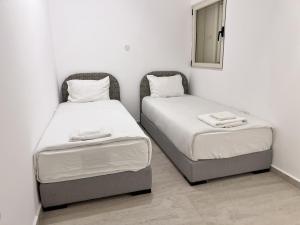two twin beds in a room with a mirror at High End Renovated Duplex near Carmel Market by FeelHome in Tel Aviv