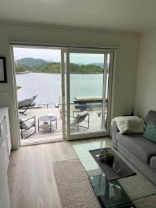 a living room with a view of the water at Amundøya Boathouse in Vadstensvik +1 photo