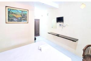 a room with a bed and a tv on the wall at Villa Bukit Bunga Syariah RedPartner Pacet in Mojokerto +25 photos