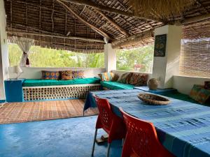 a dining room with a table and a couch at Banana Shamba Estate in Lamu