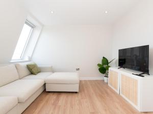 un soggiorno bianco con divano bianco e TV di Cosy Central Stylish Apartment in Twickenham Pass the Keys a Twickenham