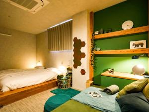 1 Schlafzimmer mit 2 Betten und einer grünen Wand in der Unterkunft Many Thanks Resort Onomichi - Vacation STAY 15794 in Onomichi
