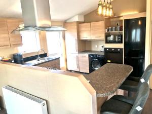 a kitchen with a table and a counter top at Hot Tub Safari Lodge in Kinmel Bay