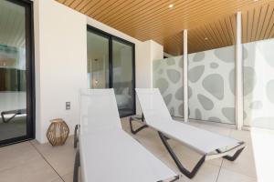 two white chairs in a room with windows at Brand-new beachside apartment, with spacious terrace and exceptional amenities, in Fuengirola in Fuengirola