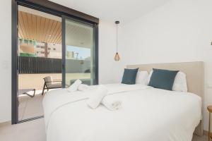 a bedroom with two white beds and a balcony at Brand-new beachside apartment, with spacious terrace and exceptional amenities, in Fuengirola in Fuengirola