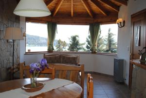 a dining room with a table and a large window at Alun Bungalows Apart in San Carlos de Bariloche