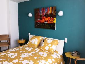 Un dormitorio con una cama con un cuadro en la pared. en Rez de jardin en bordure de ruisseau, en Le Bonhomme