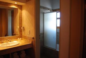 a bathroom with a sink and a glass shower at Alun Bungalows Apart in San Carlos de Bariloche +28 photos