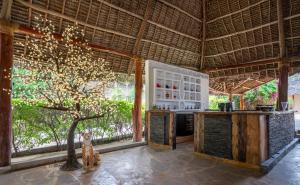 a kitchen with a tree in the middle of a room at Maharaja Boutique Hotel Zanzibar in Uroa