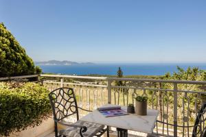 a table and chairs on a balcony with the ocean at Belle View Hotel - Sea View & Sunset in Mánganos