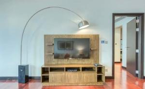 Una sala de estar con un televisor de pantalla plana en un centro de entretenimiento. en Luxury Holiday Home, Spacious 1 bedroom, Burj Alarab full ocean view, located in Anantara the palm, Palm Jumeirah, Dubai, en Dubái