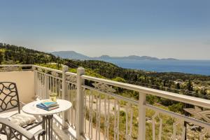 a balcony with a table and chairs and a view of the ocean at Belle View Hotel - Sea View & Sunset in Mánganos