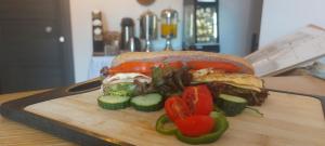 a sandwich on a cutting board with peppers and vegetables at Selinopetra Rooms in Elafonisos +34 photos