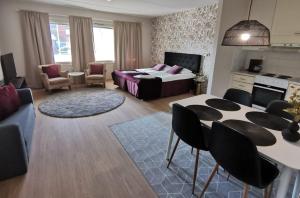 a living room with a bed and a table and chairs at Ahtinhovi in Ylivieska