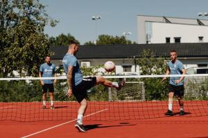 a man kicking a soccer ball on a court at Füzeskerti Apartmanház in Békésszentandrás