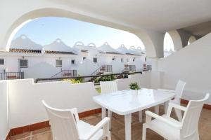 einen weißen Tisch und Stühle auf dem Balkon eines Hauses in der Unterkunft Private 2 Bedroom Flat in VIME La Reserva de Marbella in Sitio de Calahonda