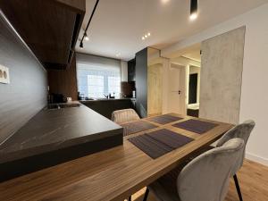 a kitchen and dining room with a wooden table and chairs at Urban Hideaway in Floreşti