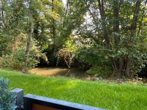 a view of a river with a bench in the grass at Sonnenbergs Quartier in Erbach
