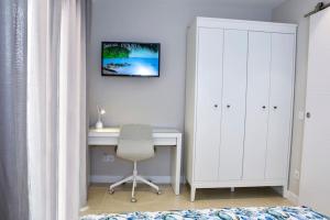 a bedroom with a desk and a white cabinet and a chair at La Sirena Playa A in Puerto de la Cruz