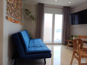 a blue couch in a living room with a window at La Sirena Playa A in Puerto de la Cruz
